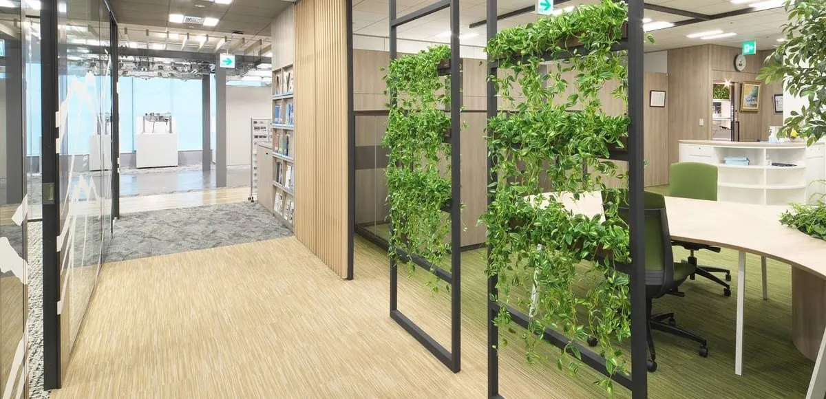 植栽を掛けた黒いフレームで、執務スペースをゆるく仕切っている