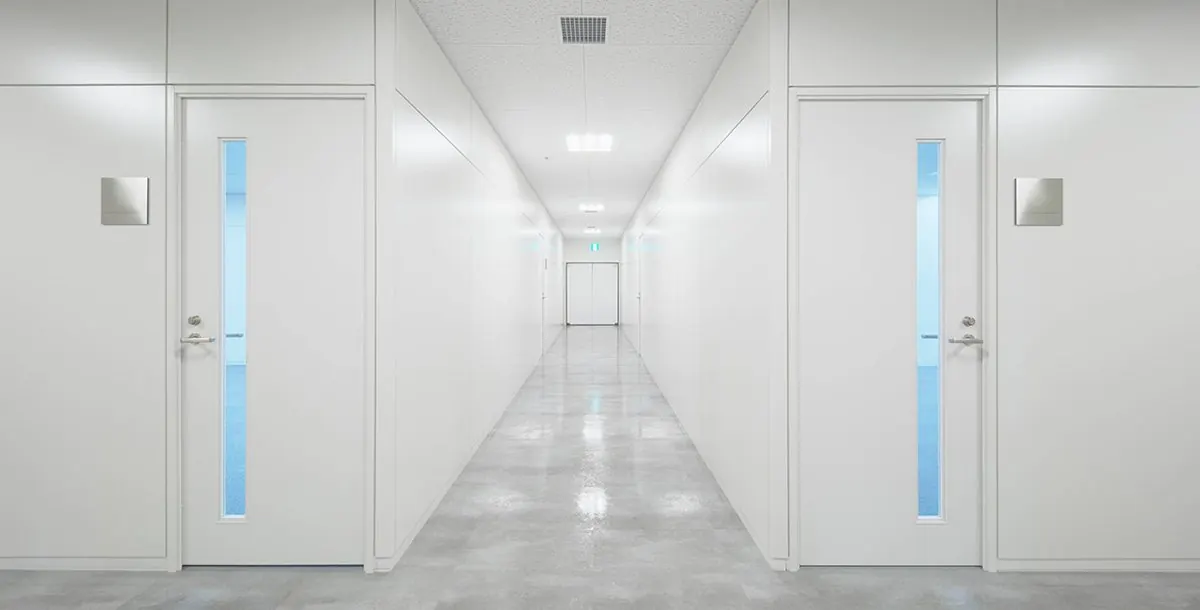 白い可動間仕切とドアが続く廊下